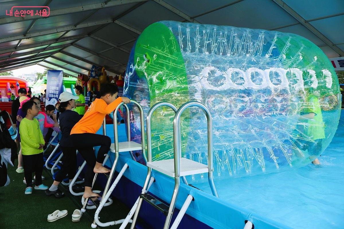 어린이들에게 인기 만점 다람쥐통 놀이기구, 한 어린이가 설레설레 들어가고 있다.