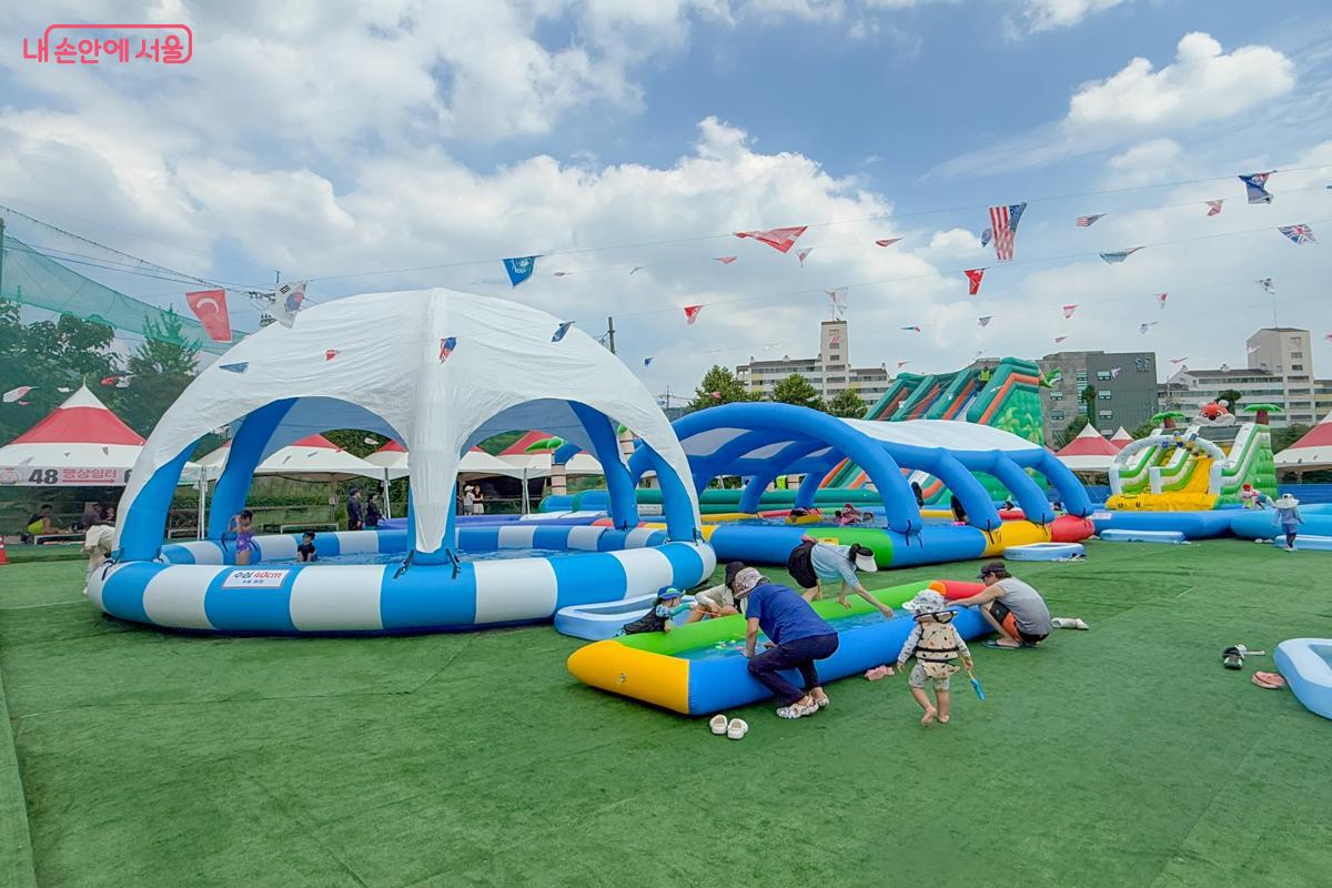 뜨거운 햇빛을 막아주는 유아풀에서 아이들이 물고기 잡기 놀이를 즐기고 있다. &copy;이미현