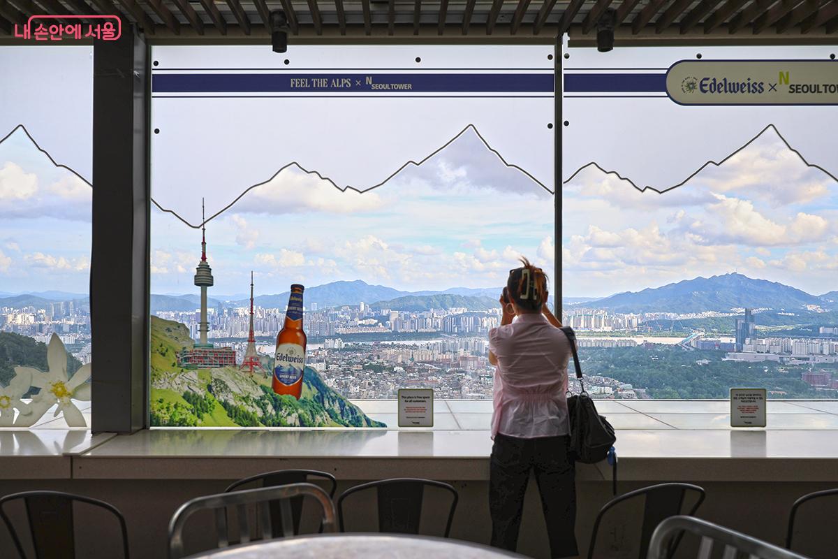 구름이 멋진 서울을 카메라에 담고 있는 관광객의 모습 ©김주연