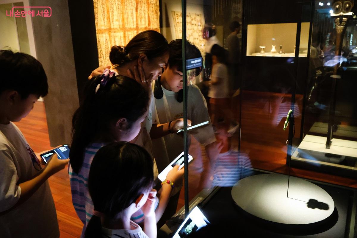 단체 관람을 하고 있는 어린이들이 각각 작품 설명 QR코드를 스마트폰에 담아 읽고 있다. ©이봉덕