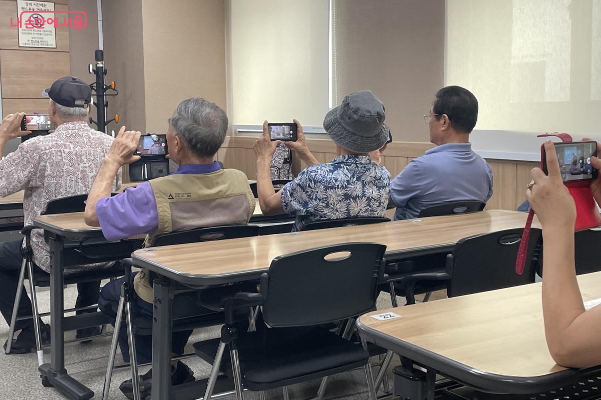 디지털배움터에서 어르신들이 스마트폰을 활용한 영상 촬영 및 편집 방법을 익히고 있다.
