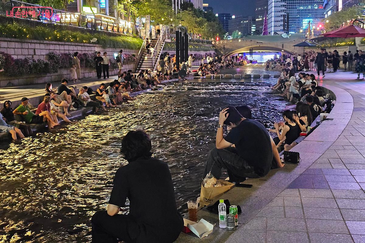열대야를 피해 청계천을 찾은 시민들이 시원한 물가에서 더위를 식히고 있다. &copy;백승훈