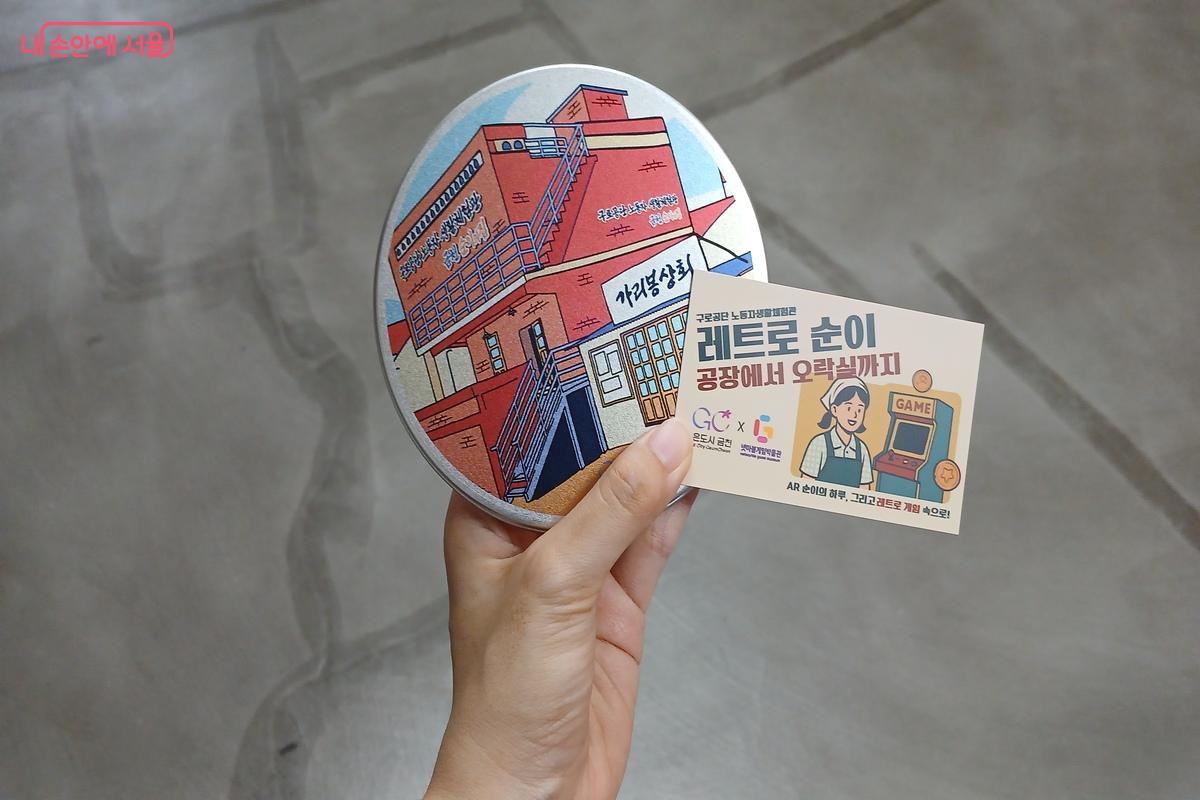 AR 체험 활동으로 받을 수 있는 달고나와 넷마블게임박물관 티켓. 달고나는 '금천 순이의 집'이 그려AR 진 케이스에 담겨있다. &copy;유지민