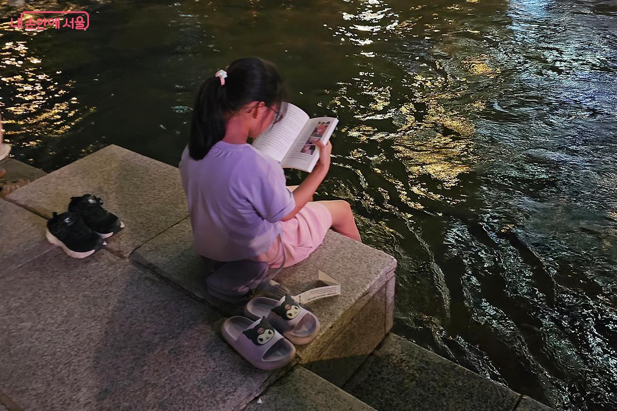 청계천에 발을 담그고 독서를 즐기고 있는 아이를 만났다. &copy;백승훈