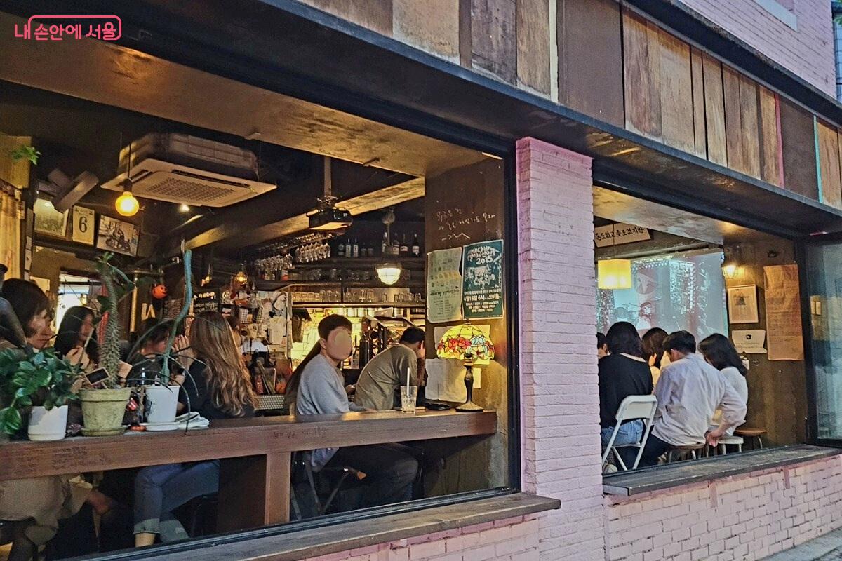 문앞에서 본 제비다방 1층. 공연이 진행 중이어서 사람들이 스크린을 향해 앉아 있다. &copy;박미선