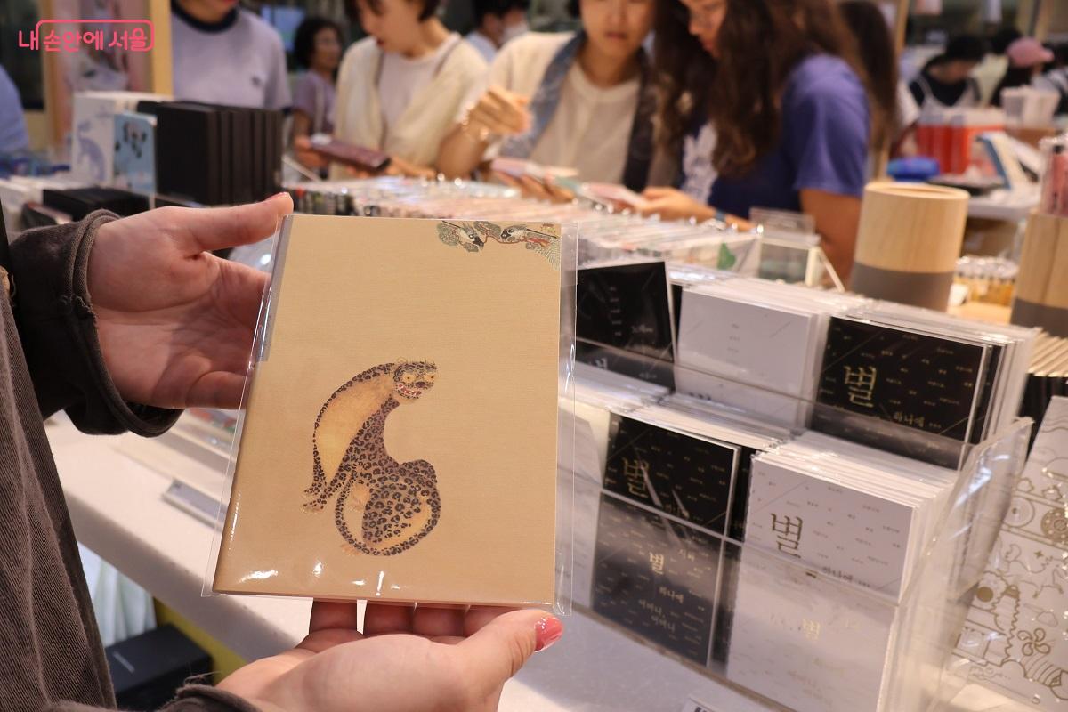 러시아 박물관에서 근무하는 한 러시아인이 <케이팝 데몬 헌터스>에 나오는 호랑이 캐릭터를 모티브로 제작된 노트를 골랐다며 자랑했다. ©이봉덕