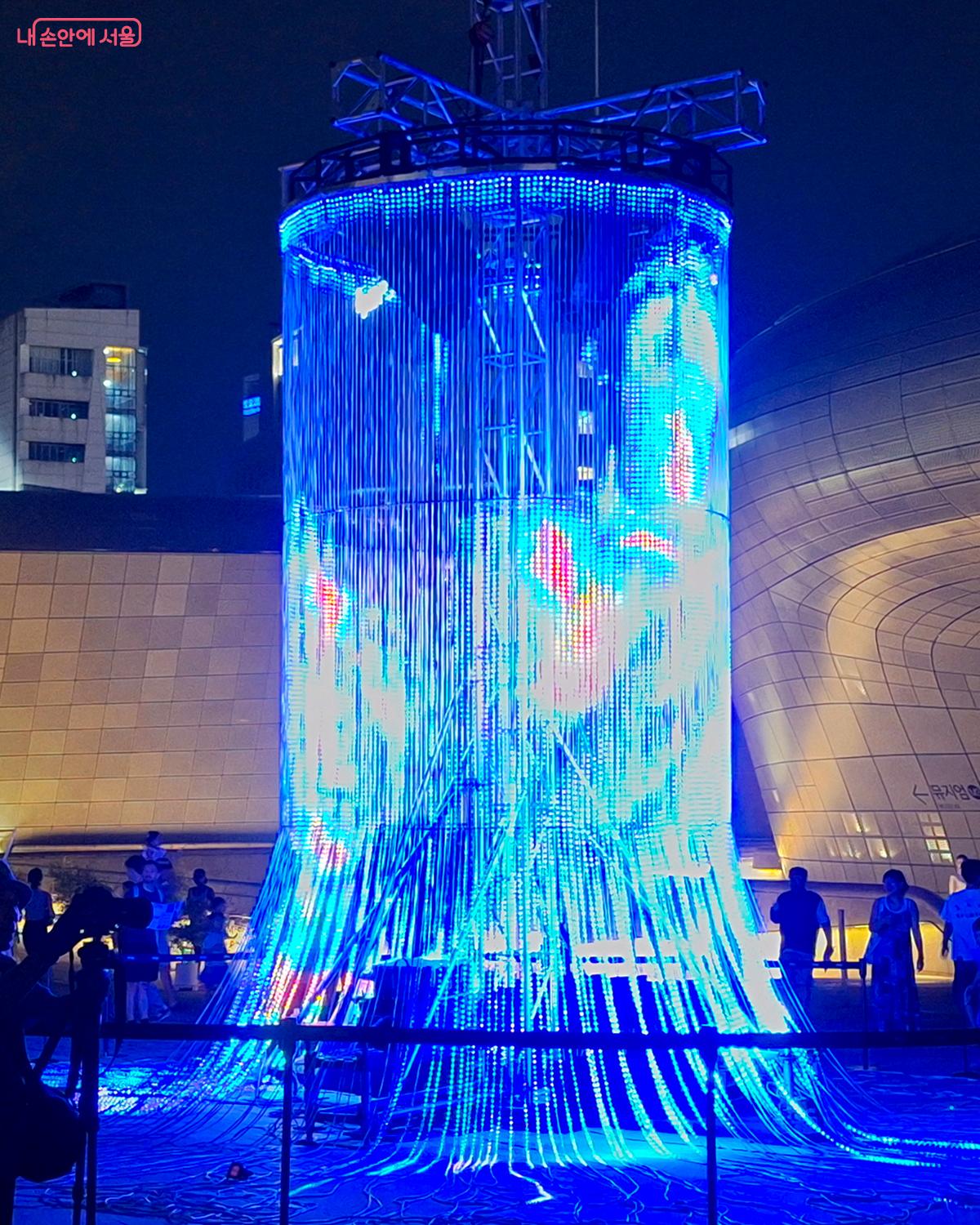  폴란드 전위 예술 작가 '크사베리 컴퓨터리'의 최첨단 미디어 작품 'Flux'는 디지털과 현실의 경계를 허물며 설치 미술의 정점을 보여준다.