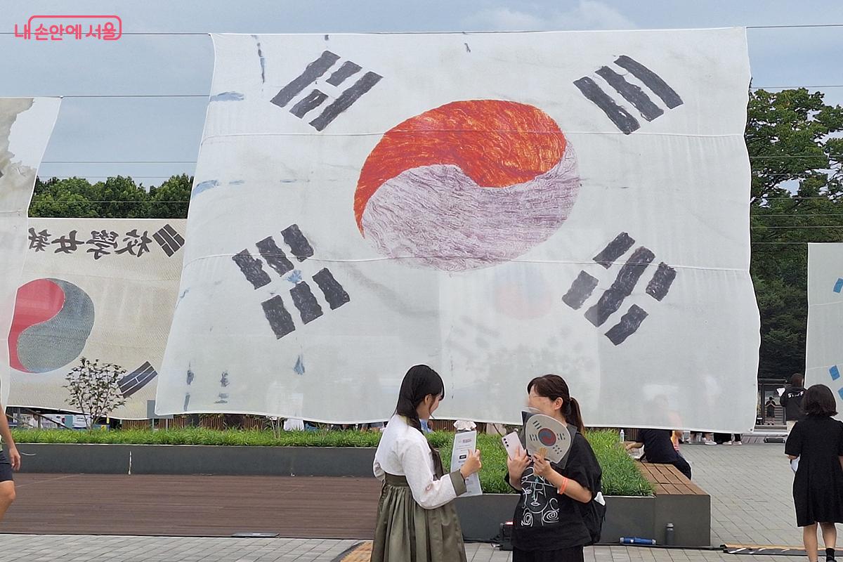 &lsquo;남상락 자수 태극기&rsquo; 앞에서 한복을 곱게 차려입은 진행 요원의 모습이 눈에 띈다. &copy;백승훈