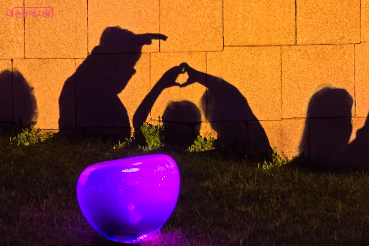 작품 앞에서 그림자 놀이를 하는 가족들 ©김윤경