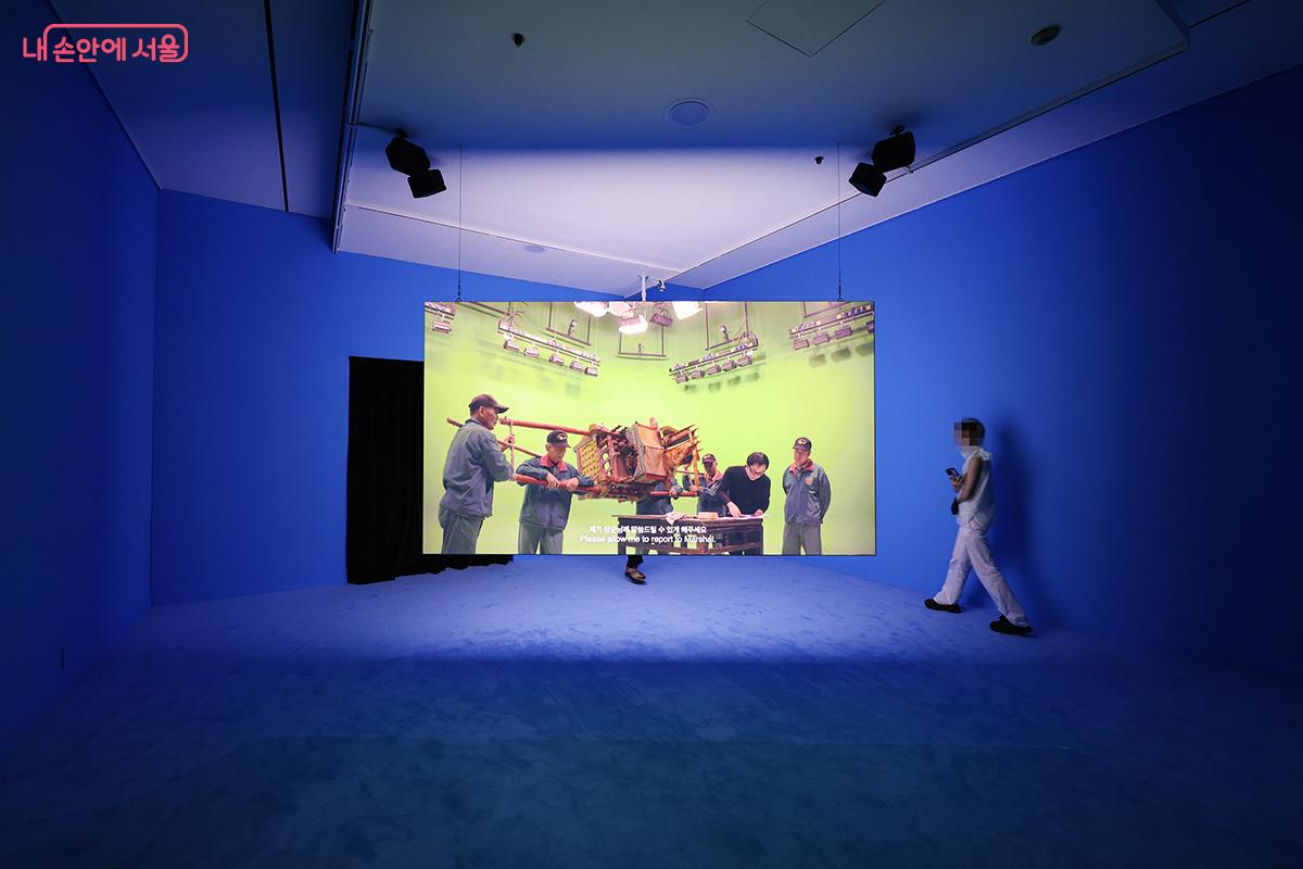 푸른 공간 속 2개의 대형 화면이 인상적인 전시공간 ©김주연