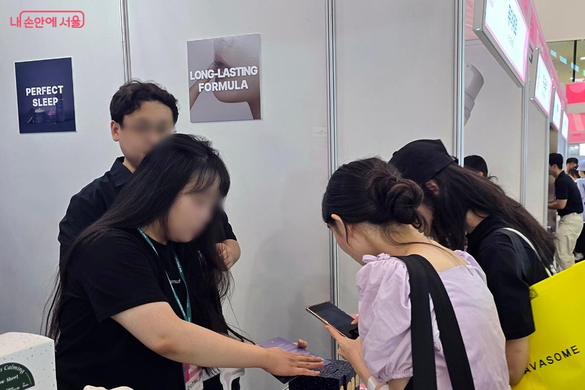 관람객이 제품에 관한 설명을 듣고 있다. ©김윤경