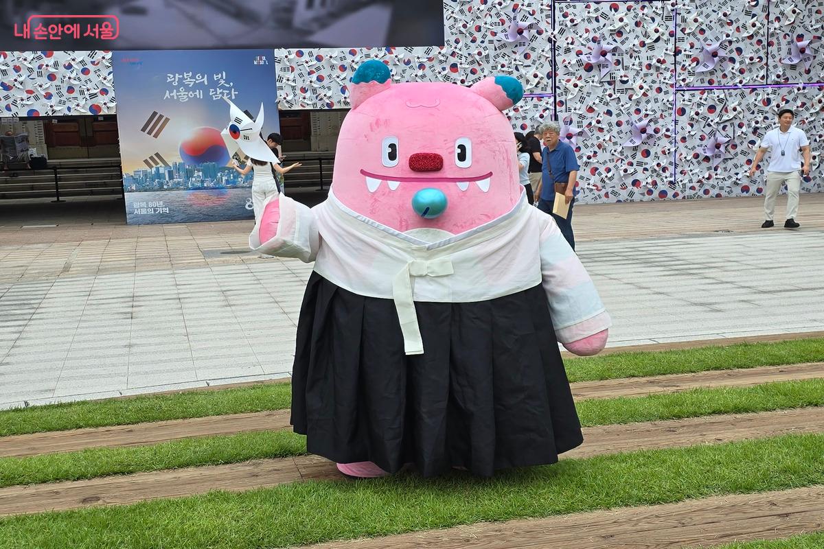 태극기를 손에 들고 한복을 입은 광복 해치가 서울 시민들과 함께 사진을 찍고 있다. ©김은주
