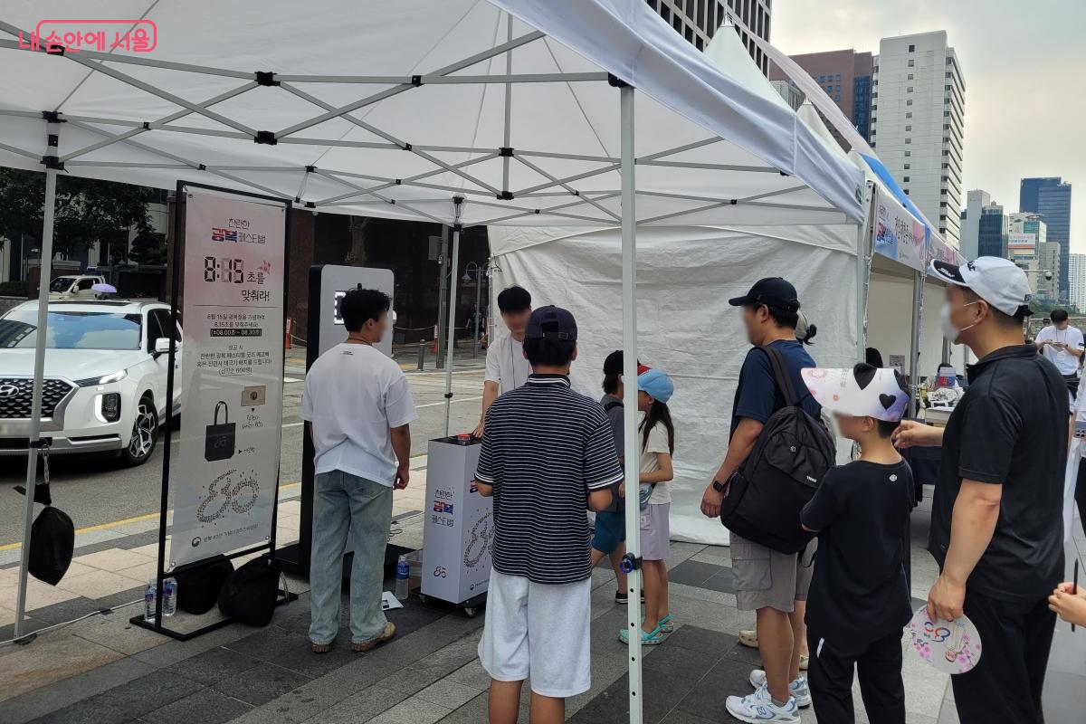 8.15초를 맞추는 타이머 게임에 참여하는 시민들