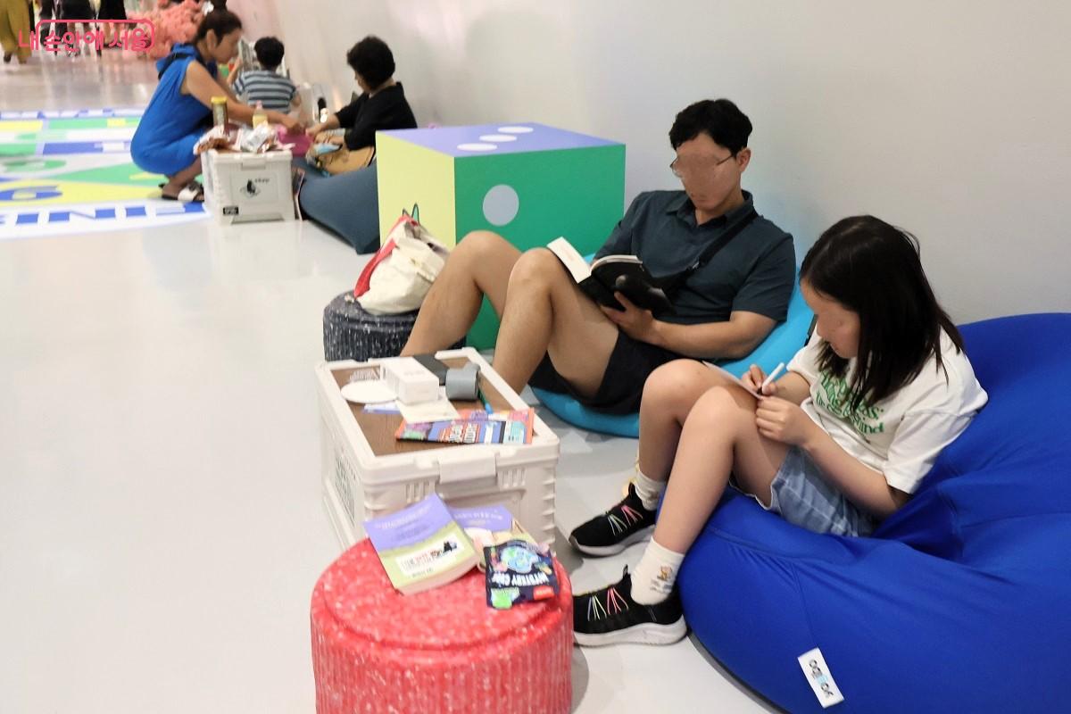 홀리데이 북크닉 코너에서 아빠와 어린이가 함께 책을 읽고 있는 모습 ©이봉덕