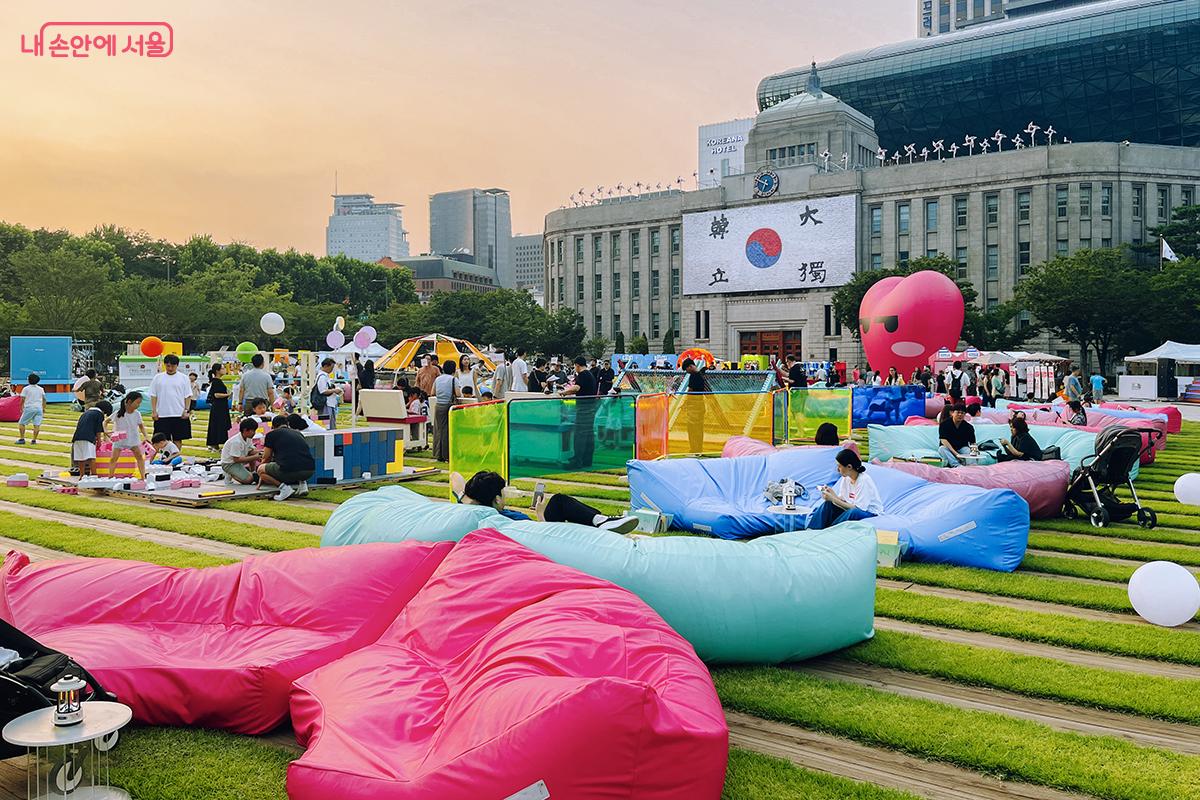 서울광장의 푸른 잔디와 서울 브랜드 색을 담은 알록달록한 빈백, 노을빛 하늘이 어우러진 아름다운 여름날 오후의 풍경 ©김아름