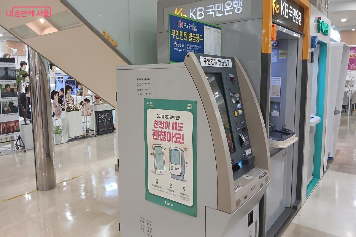 무인민원 발급기 옆에 디지털 약자와의 동행 포스터가 붙어 있다. &copy;유지민