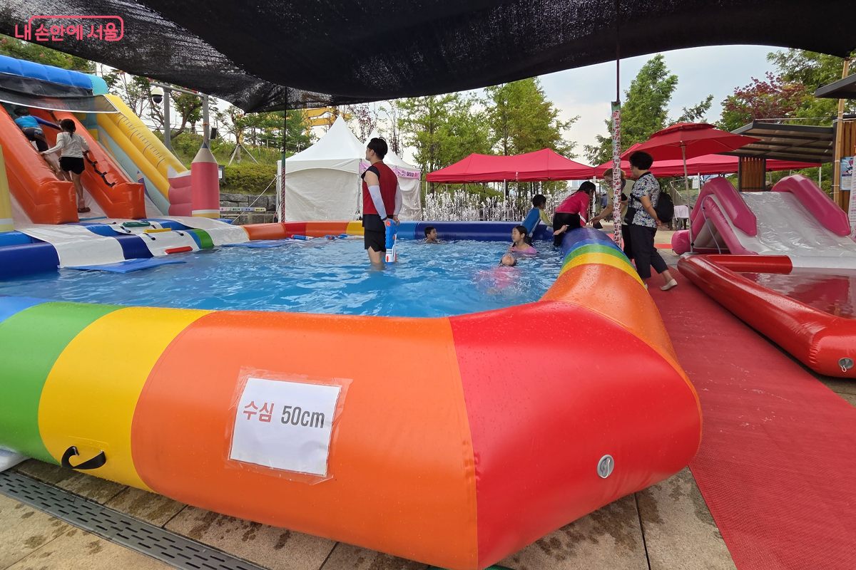 아이들이 물놀이에 푹 빠진 사이, 시원한 그늘막 아래에서 부모들이 지켜본다. &copy;장미화