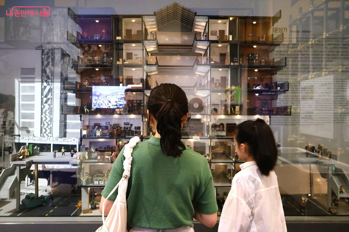 엄마와 아이가 이야기를 나누며 당시의 서울 사람들의 생활상을 살펴보고 있다. ©이봉덕