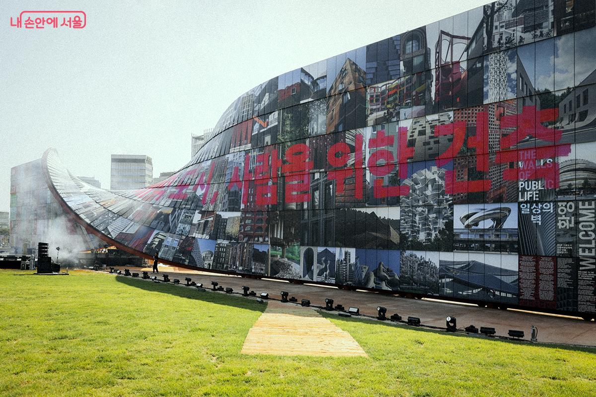 길이 90미터, 높이 4층 규모의 거대한 벽은 총 1,428장의 철판으로 구성되어 있으며 각 철판에는 전 세계 시민, 과학자, 디자이너들이 제안한 창의적인 건축 아이디어가 담겨 있다. ⓒ김아름