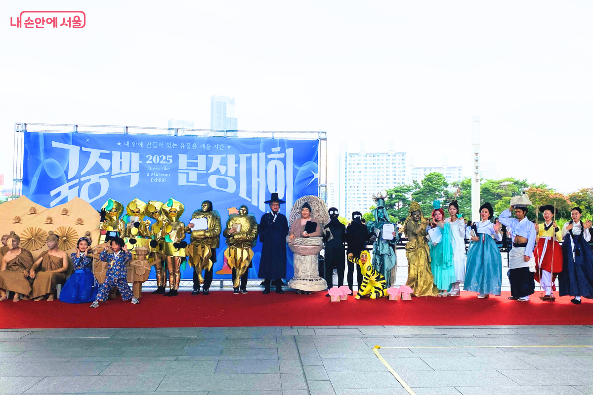 본상 수상 10팀 전원과 유홍준 국립중앙박물관장이 무대 위에 나란히 서서 단체 기념사진을 찍고 있다. 각양각색의 유물 분장을 한 참가자들과 유홍준 관장이 함께 포즈를 취하고 있다. ©양정화