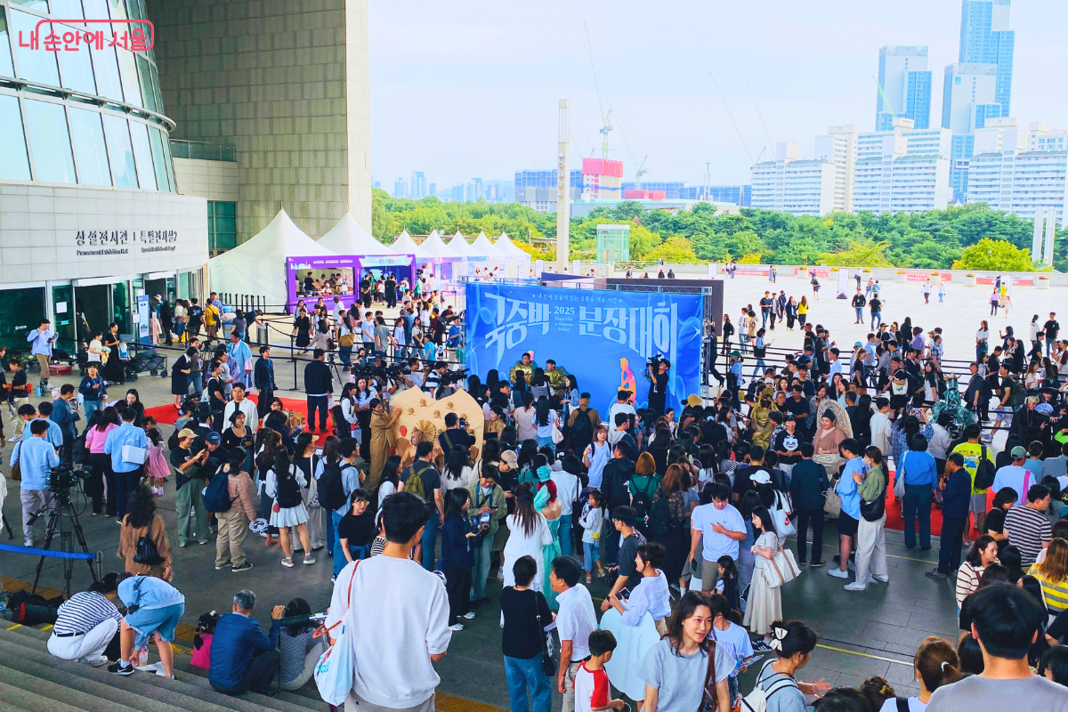 시상식이 끝난 후 국립중앙박물관 광장에서 본상 수상팀들이 수많은 시민에게 둘러싸여 있다. 시민들은 유물 분장을 한 참가자들의 사진을 찍으며 즐거운 시간을 보내고 있으며, 현장은 축제 분위기로 가득하다. ©양정화