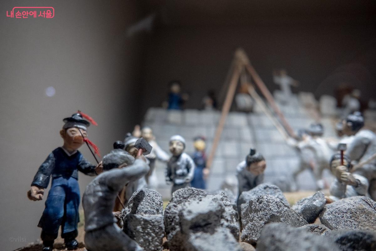 성돌을 쌓아가면서 무너진 성벽을 재건하는 모습을 재현한 디오라마
