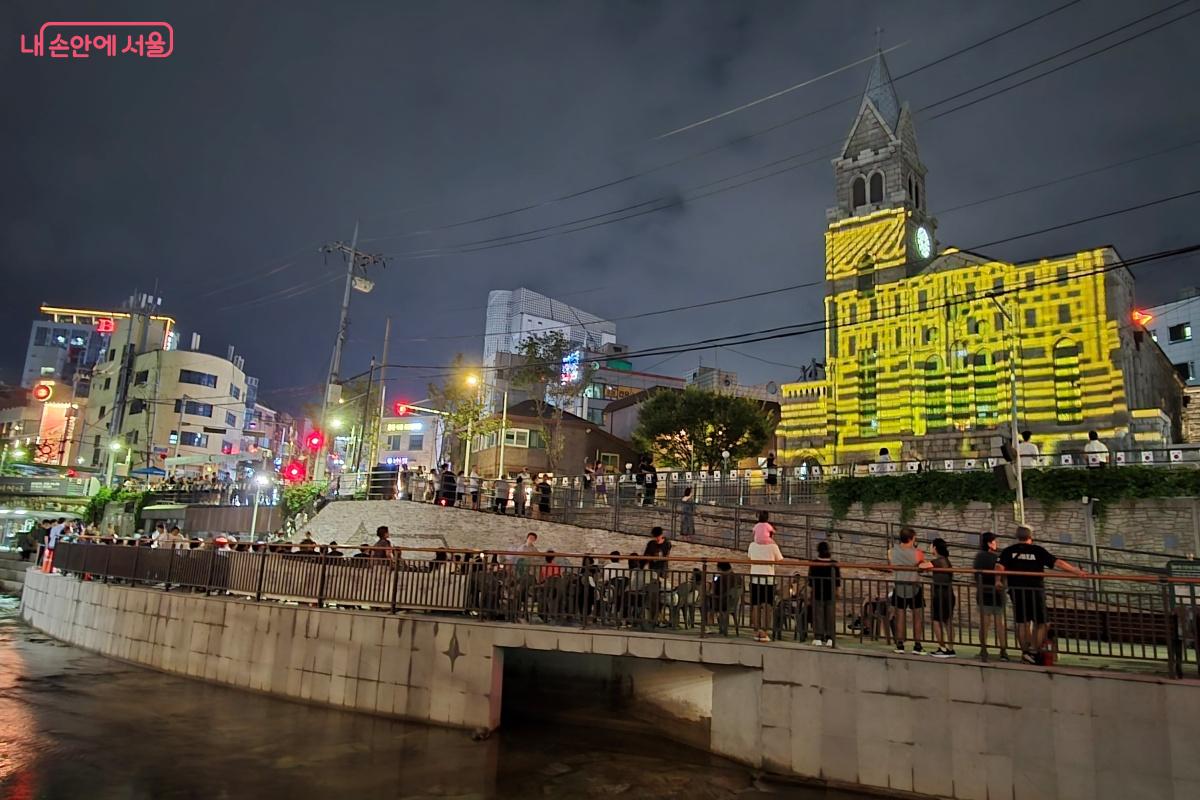 성당 외벽과 제방 벽에 빛으로 만든 영상을 투사한다. ©김미선