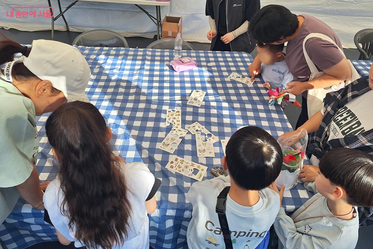 '스티커 타투' 부스에서 온가족이 모여 서로의 손등 위에 일회용 타투를 새기며 즐거운 시간을 보냈다.