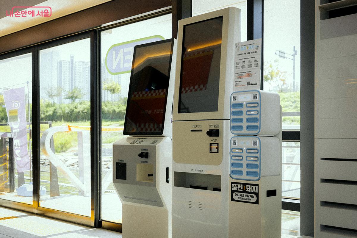 입구 근처에 마련된 티켓 발권기(시각 장애인용 포함 2대)와 보조배터리 대여기 &copy;김아름