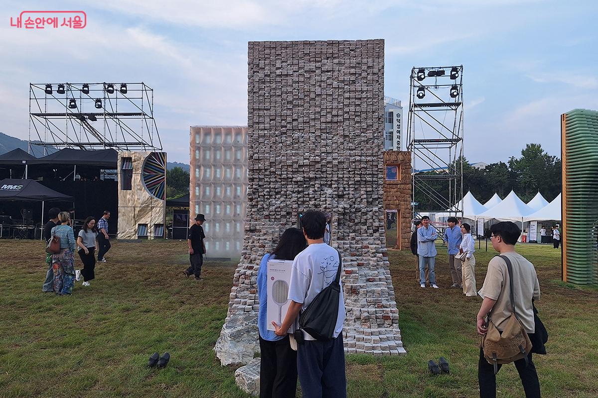 아이들이 조형물 주변을 뛰노는 밝은 웃음소리와 연인들이 서로의 손을 잡고 작품을 감상하는 모습은 이 공간이 주는 평화로움과 소통의 가치를 대변하는 듯하다. 