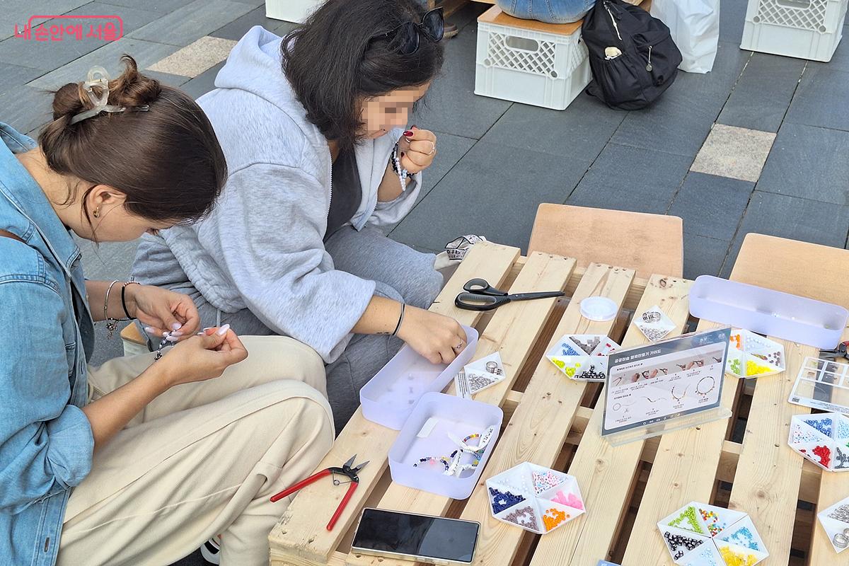&lsquo;공공미술 팔찌 만들기&rsquo; 체험 코너에서 외국인 관광객들이 나만의 팔찌를 만들고 있다. &copy;백승훈