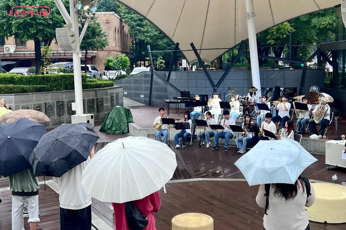 성균관대학교 '관악대'와 우산을 쓰면서 공연을 관람하는 시민들의 모습 ©민정기