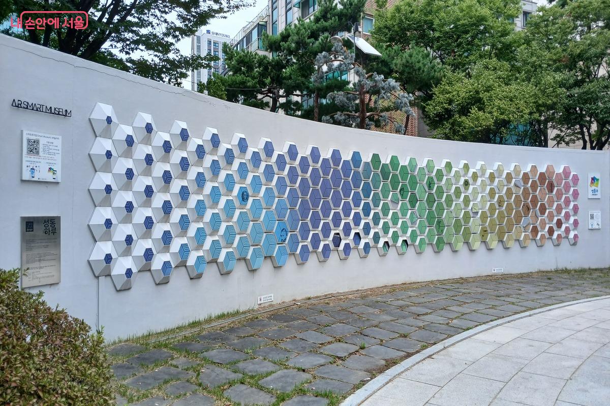 무지갯빛으로 만들어진 벽에 붙은 조형물 ©유지민