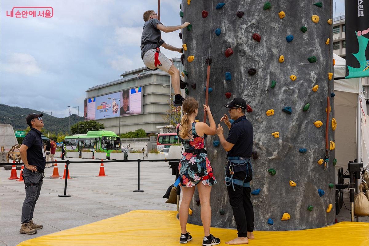 외국인 참가자가 클라이밍 체험존에서 암벽에 도전하고 있다. &copy;장신자
