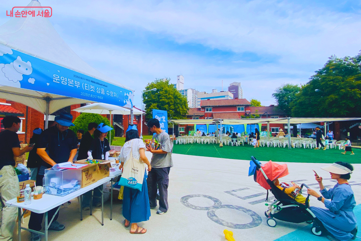 '운영본부'라고 적힌 천막 아래에서 축제 스태프들이 시민들에게 기념품을 나눠주고 있다. 미션을 완료한 시민들이 줄을 서서 선물을 받아가고 있다. ©양정화