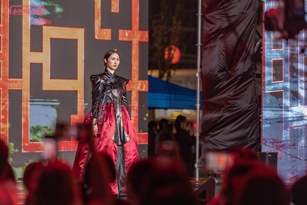 붉은빛 조명 아래, 전통 한복을 재해석한 미래형 디자인이 런웨이를 장식했다.