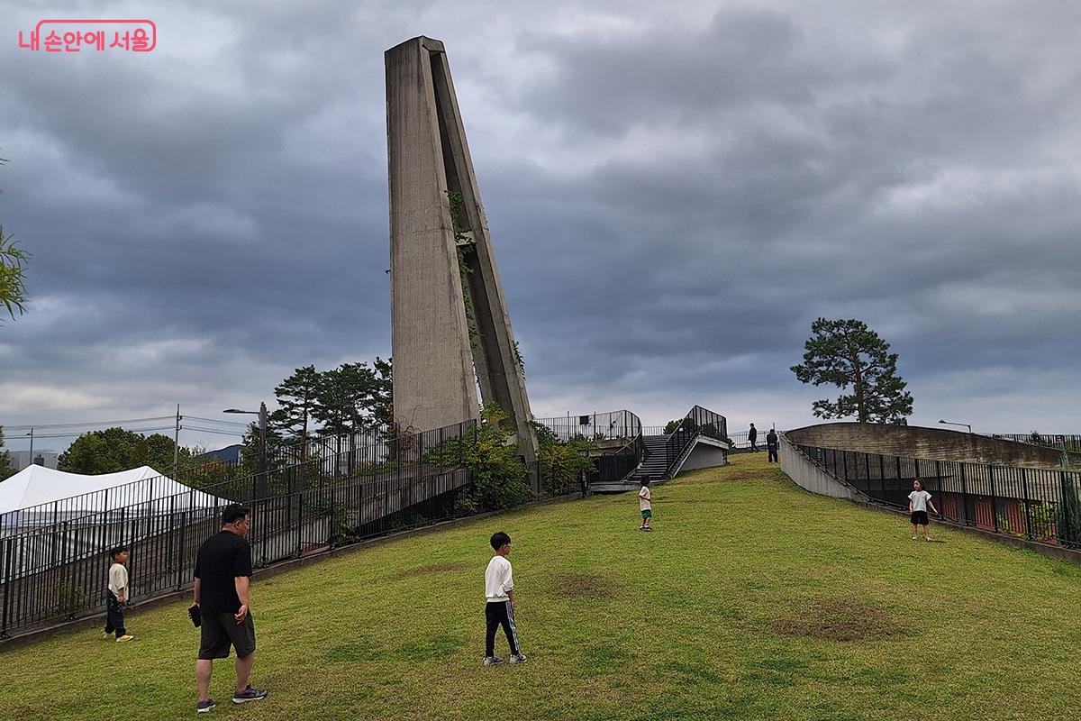 관리사무소 위로 조성된 잔디 언덕에서 아이들이 공놀이를 하며 즐겁게 노는 모습 ©이혜숙