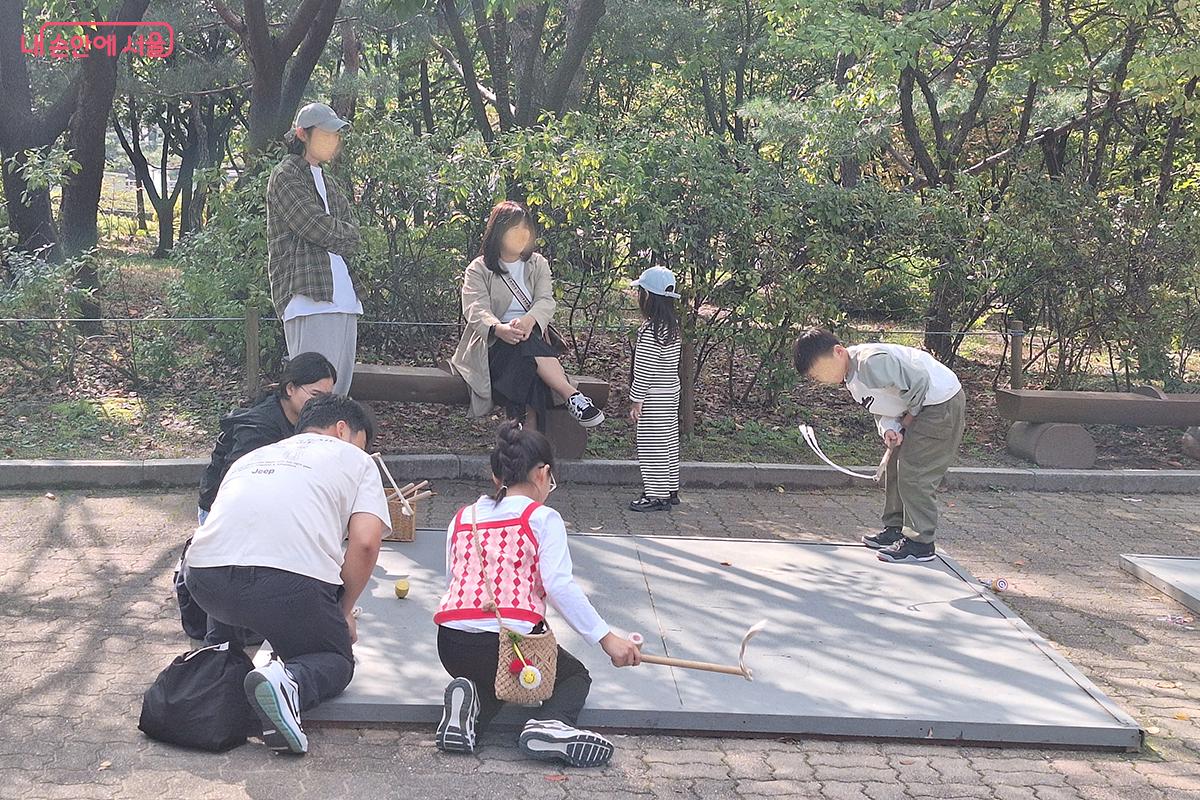 '전통놀이체험' 코너에서 한국전통 방식의 '팽이치기' 놀이를 즐기고 있는 가족들의 모습 ©백승훈