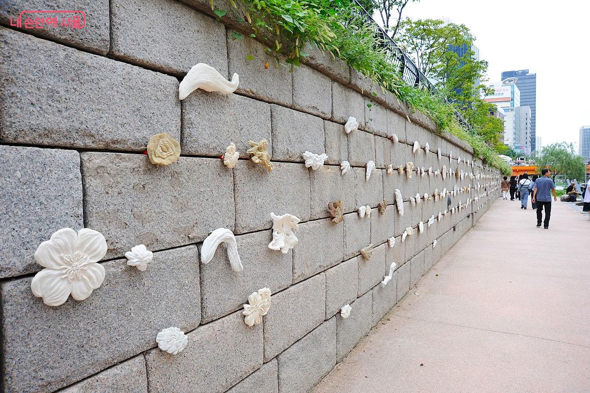 광통교와 광교 사이 좌안 벽에 설치된 전영은 작가의 <청계초록: 눈길 손길> ©조수봉