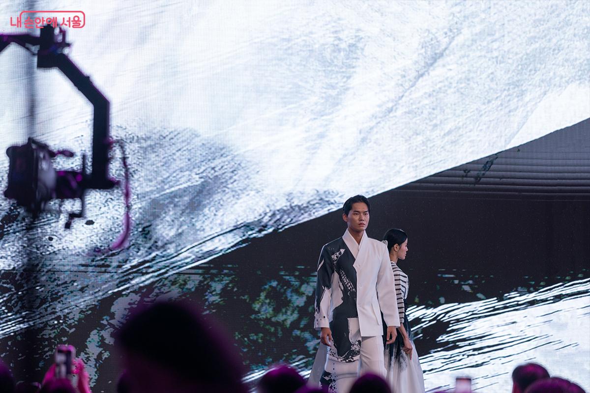 흑백의 대비가 돋보이는 의상과 배경, 전통 수묵화의 질감이 현대 패션으로 재해석되었다. ⓒ장신자