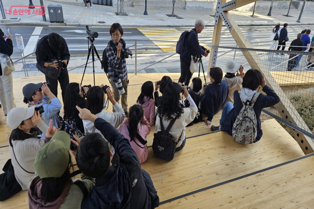 탐조 참석자들이 ‘커넥션 파빌리온’에 앉아 망원경 사용법을 익히고 있다. ©이선미