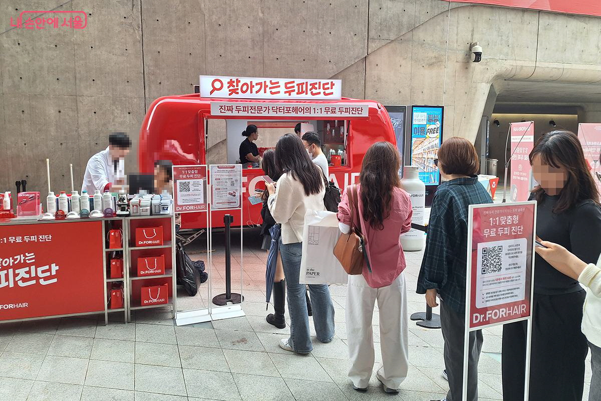 두피 관련 전문 케어 체험 코너에서 직접 전문가에게 일대일 상담을 받고 경품도 받는 참가자들의 모습 ©백승훈