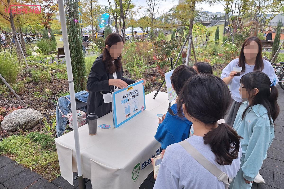 자원봉사자들이 ‘아리수 와우카’를 이용하는 어린이들에게 아리수의 의미와 역할 등을 설명해주고 있다. ©이혜숙