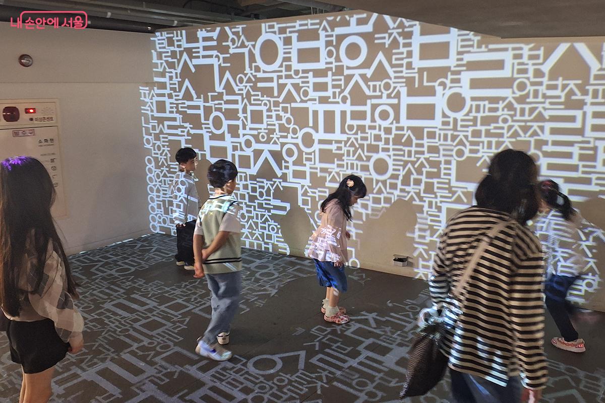 아이들이 레이저로 비친 한글 자모 공간에서 신나게 뛰놀고 있다. ©백승훈