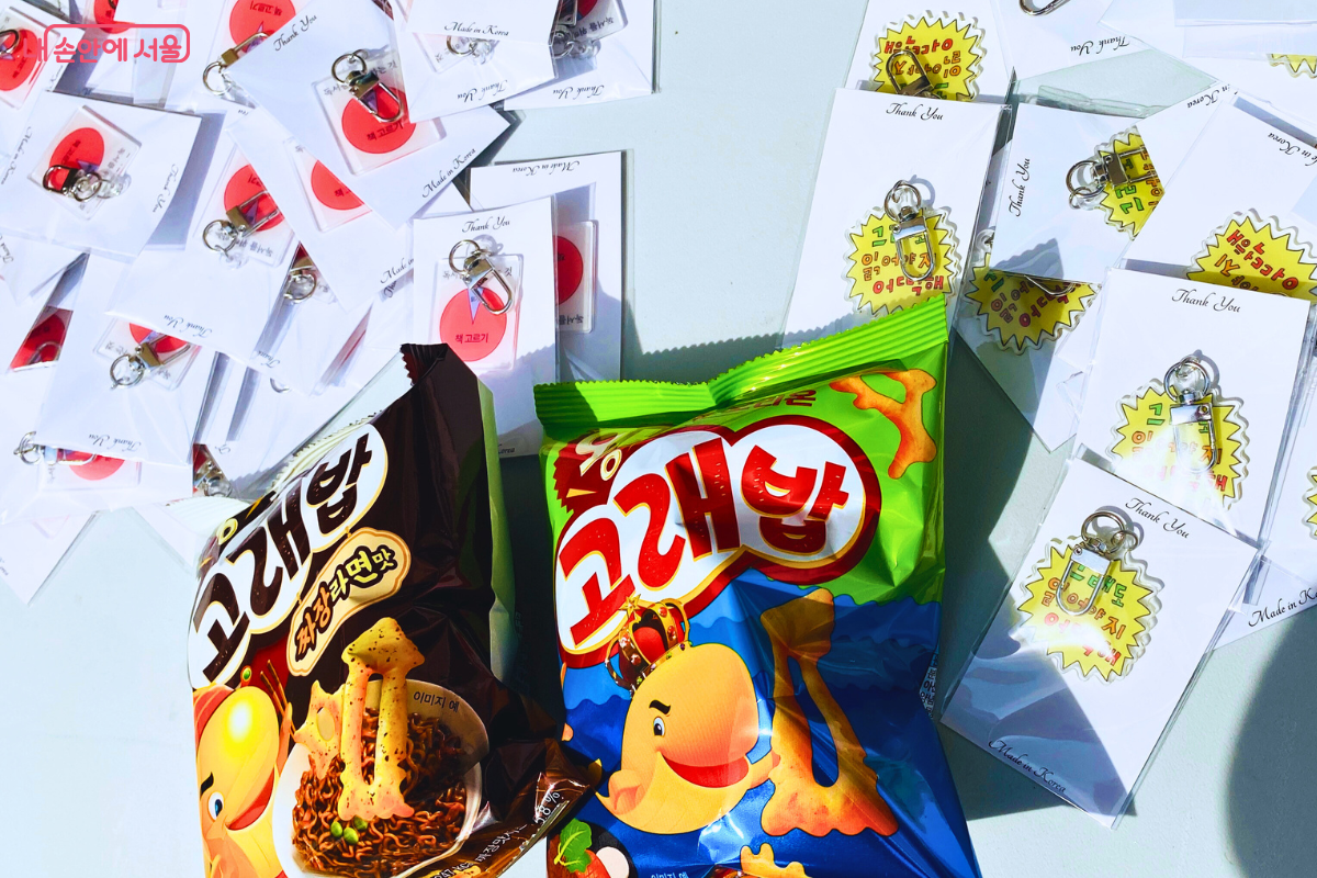 축제 방문객들에게 제공된 기념품들이 테이블 위에 놓여 있다. 후원처인 오리온 '고래밥' 과자들과 함께 여러 종류의 키링이 개별 포장되어 있다. ©양정화