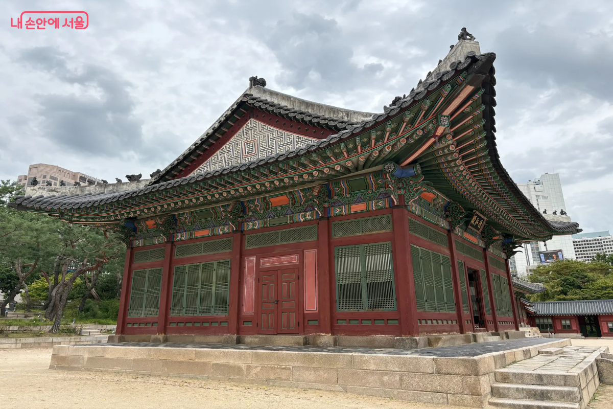 붉은 빛깔의 벽면과 화려한 단청이 눈에 띄는 덕홍전의 모습 ©이혜린