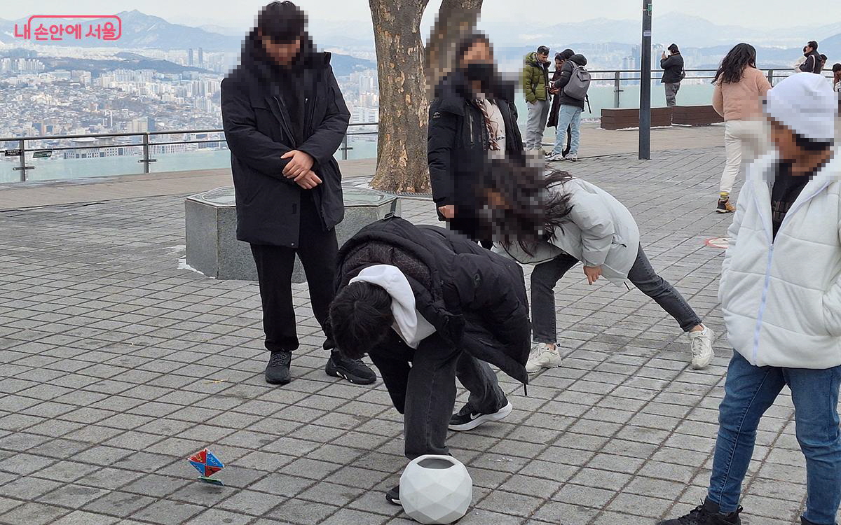 어릴 적 순수한 즐거움을 떠올리게 하는 딱지치기를 하며 소중한 기억을 되새긴다. &copy;이혜숙