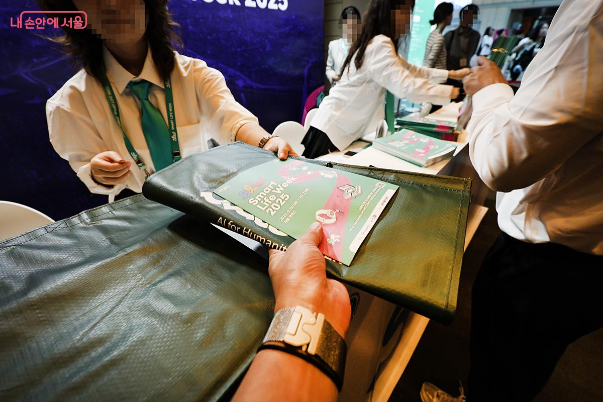 입장객 전원에게 안내 책자와 자료 및 선물을 담을 수 있는 가방을 나눠 줬다. ©김주연