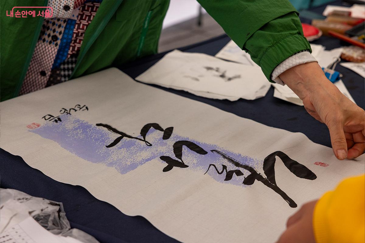 빛모락 가을축제 체험 부스에서 시민이 직접 글씨를 쓰는 시간. 붓끝에 담긴 따뜻한 마음이 한지 캘리그라피 ⓒ장신자