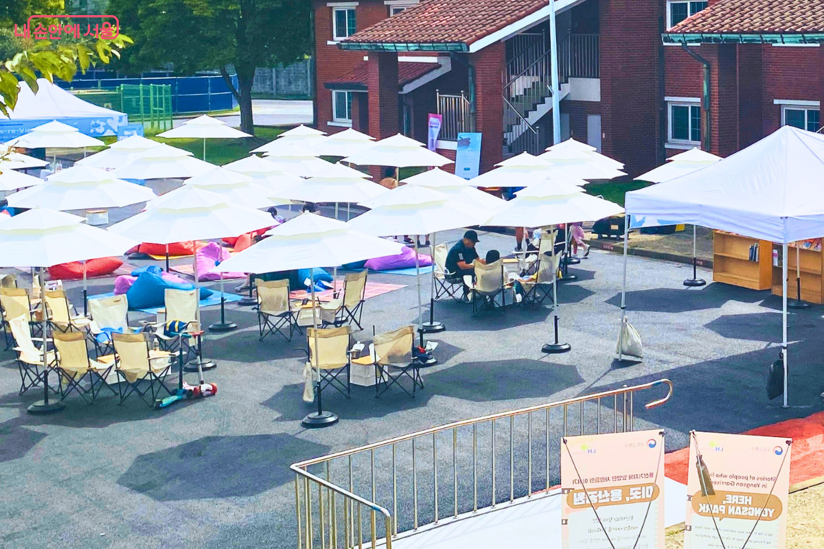 행사장 한편에 마련된 '사일런트 독서존'의 모습. 수십 개의 하얀 파라솔 아래에 알록달록한 빈백과 캠핑 의자가 놓여 있고, 시민들이 편안한 자세로 독서를 즐기고 있다. ©양정화